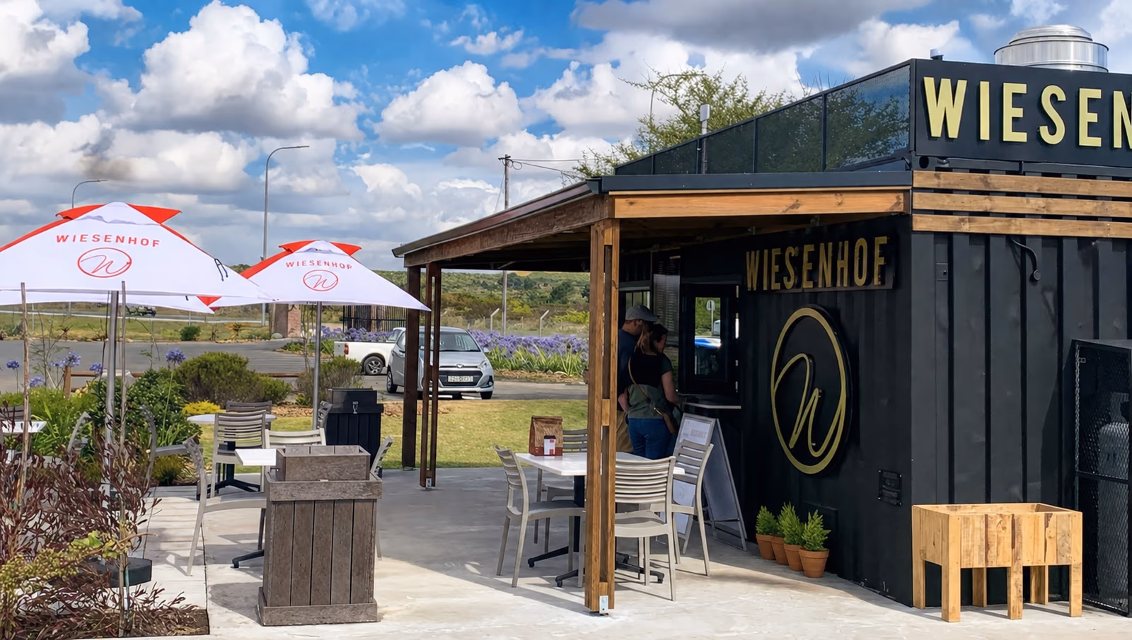A Wiesenhof coffee shop built from a converted container, with an outdoor seating deck