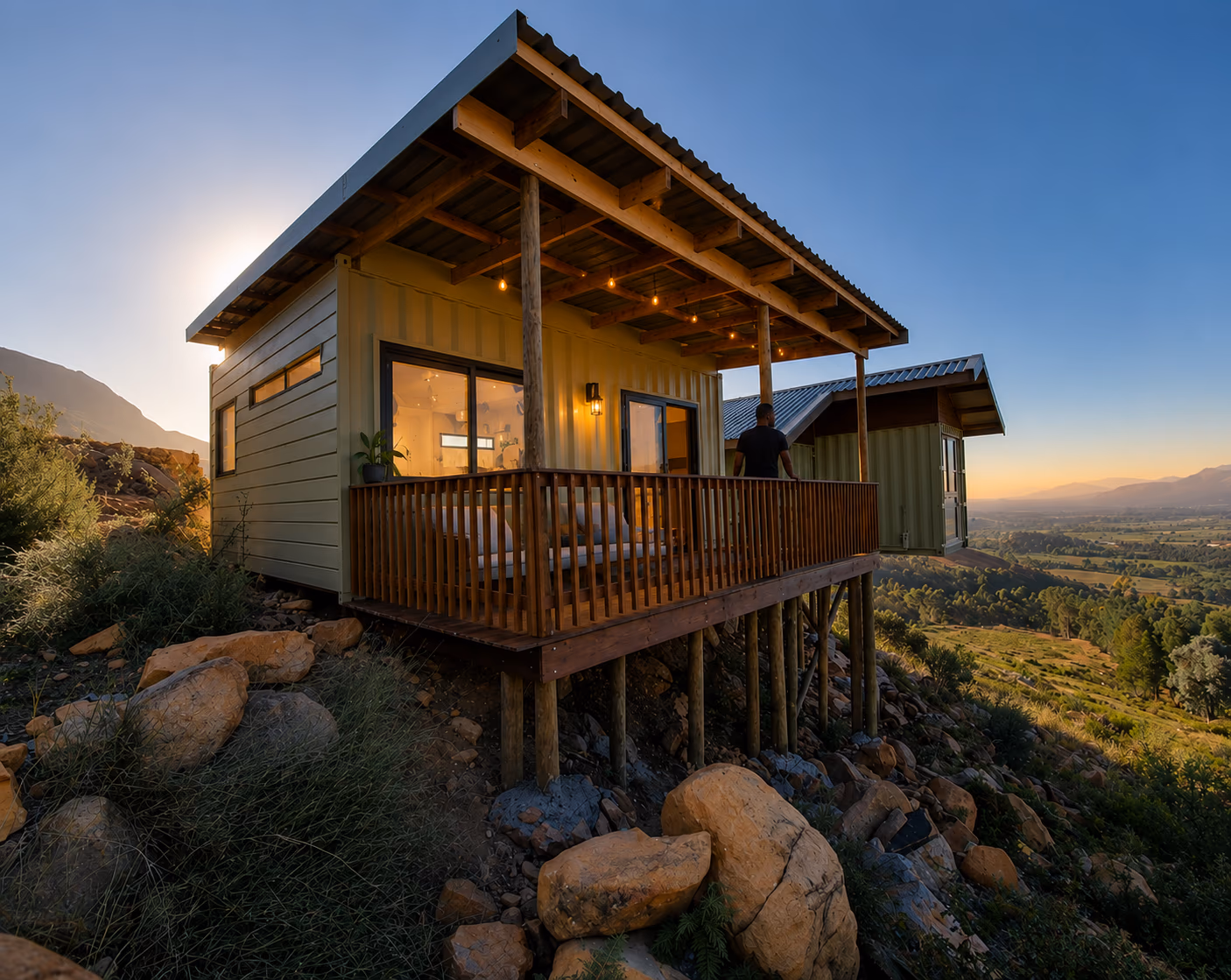 Styled render of The Studio on a rocky hillside at golden hour, with its raised deck